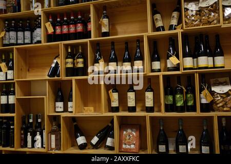 Enoteca. Ripiani in legno con vini rossi toscani a vista. Foto Stock