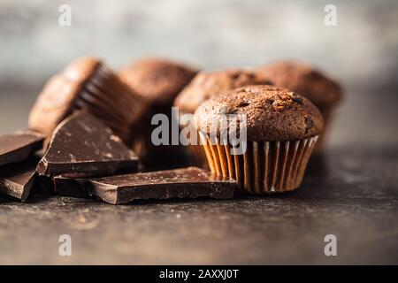 Gustosi muffin al cioccolato. Tortine dolci e cioccolato su vecchio tavolo da cucina. Foto Stock