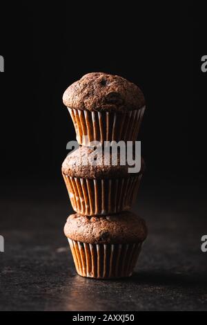 Gustosi muffin al cioccolato. Cupcake dolci su vecchio tavolo da cucina. Foto Stock