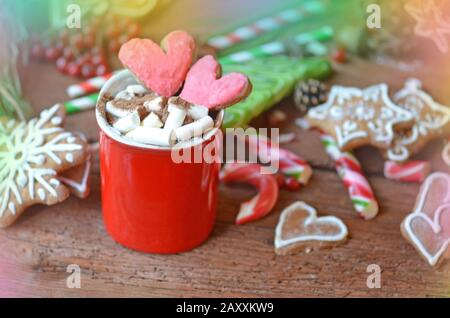 Cioccolata calda e biscotti a forma di cuore sulla superficie di legno. Bevande per una coppia amorevole Foto Stock