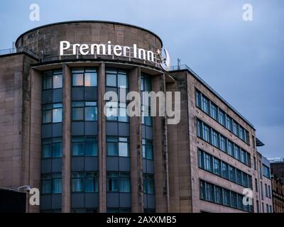 Cartello con il nome al neon del Premier Inn Lit al crepuscolo, George Street, Glasgow, Scozia, Regno Unito Foto Stock