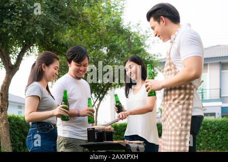 Cucina asiatica griglia barbecue e salsiccia per un gruppo di amici a mangiare in giardino a casa. Gruppo di amici con giardino all'aperto barbecue la Foto Stock