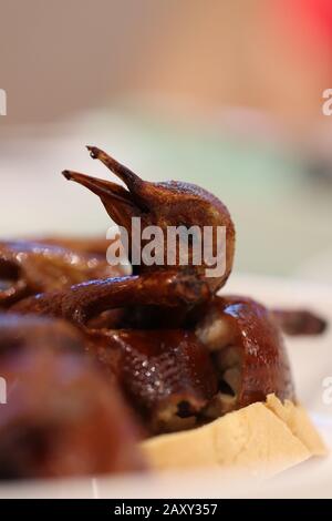 Piatto d'anatra alla pechinese/arrosto servito in un ristorante cinese. La testa d'anatra di pechino è a fuoco tra l'intero corpo. Foto Stock