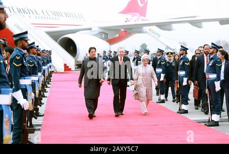 (200214) -- ISLAMABAD, 14 febbraio 2020 (Xinhua) -- Foto rilasciata dal Pakistan Press Information Department (PID) mostra il primo ministro pakistano Imran Khan (L) a piedi accanto al presidente turco Recep Tayyip Erdogan (C) e sua moglie Emine Erdogan al loro arrivo a Islamabad, Pakistan, 13 febbraio 2020. Il presidente turco Recep Tayyip Erdogan è arrivato giovedì in Pakistan per una visita di due giorni. (PID/consegna tramite Xinhua) Foto Stock