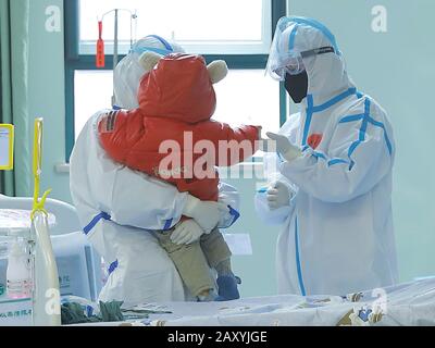 (200214) -- WUHAN, 14 febbraio 2020 (Xinhua) -- un personale medico tiene un bambino di 14 mesi recuperato dalla nuova polmonite da coronavirus prima del suo scarico dal Wuhan Children's Hospital di Wuhan, capitale della provincia dell'Hubei nella Cina centrale, 13 febbraio 2020. Un bambino di 14 mesi infettato con il nuovo coronavirus fu dimesso dall'ospedale giovedì dopo il recupero nella provincia di Hubei nella Cina centrale. Il bambino è stato inviato all'ospedale il 26 gennaio dopo aver avuto diarrea e vomito per sei giorni. Tuttavia, ha ancora mostrato sintomi come respiro corto dopo il trattamento, in modo da è stato inviato Foto Stock