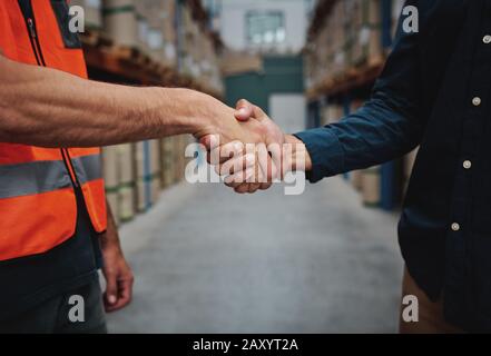 Primo piano di due uomini stretta di mano, concludendo l'accordo sul noleggio di container e scuotendo le mani Foto Stock