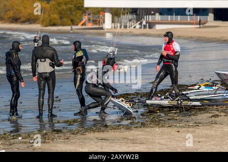 Tallinn, Estonia - 18 ottobre 2008: Windsurf in abiti si preparano a cavalcare. Tavole a vela si trovano sul mare. Hotel sfocato sullo sfondo. Foto Stock