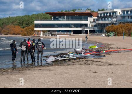 Tallinn, Estonia - 18 ottobre 2008: Windsurf in abiti si preparano a cavalcare. Tavole a vela si trovano sul mare. Il tempo è nuvoloso. Caldo sfocato Foto Stock