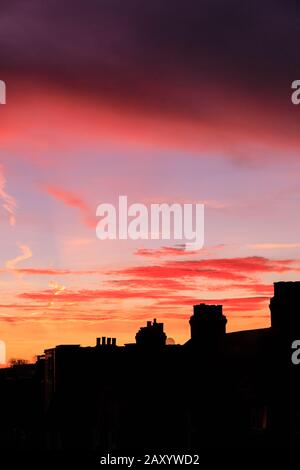 Londra, Regno Unito. 14th Feb, 2020. Un bell'alba rossa e arancione con colorate formazioni a nuvola appare sopra le cime del tetto di South East London, appena in tempo per San Valentino 2020. Credito: Imageplotter/Alamy Live News Foto Stock