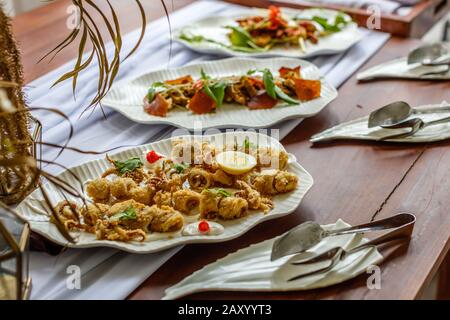 Calamari fritti e martoriati con salsa di catrame e limone serviti su un piatto bianco di ceramica. Foto Stock