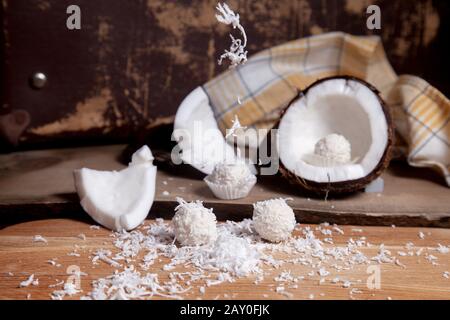 Primo piano di tartufi di cocco cioccolato dolce e cocco con polpa bianca, chip di cocco. Cioccolato bianco cocco dolci e guscio di cocco, cocco flak Foto Stock