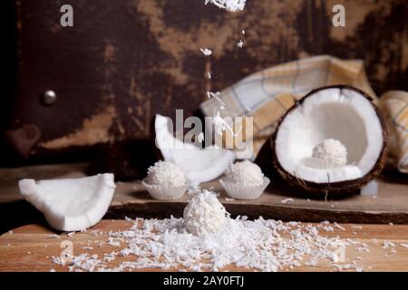 Primo piano di tartufi di cocco cioccolato dolce e cocco con polpa bianca, chip di cocco. Cioccolato bianco cocco dolci e guscio di cocco, cocco flak Foto Stock