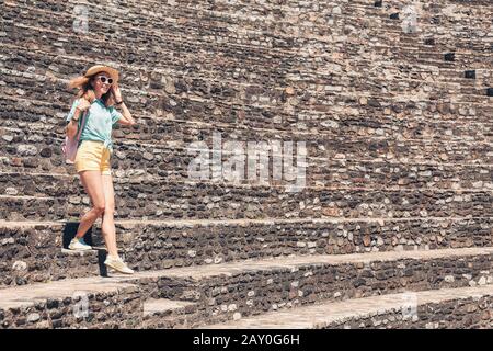 Ragazza turistica a piedi in antiche ruine romane o greche di anfiteatro antico Foto Stock