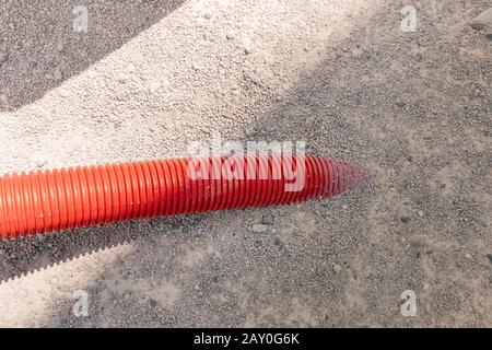 Tubo di plastica che attraversa il suolo. Concetto industriale e di pompaggio Foto Stock