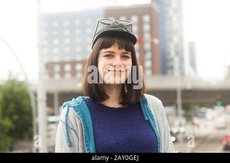 Ritratto di una donna sorridente in piedi all'aperto in città, Germania Foto Stock