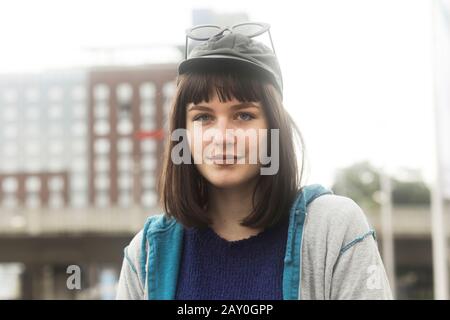 Ritratto di una donna sorridente in piedi all'aperto in città, Germania Foto Stock