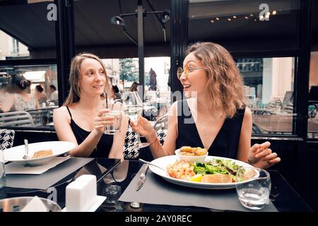 Due amici femminili celebrano un evento e brindano al ristorante Foto Stock