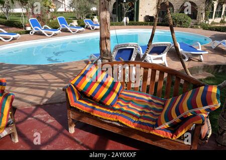 Comodo divano vicino alla piscina dell'hotel Foto Stock