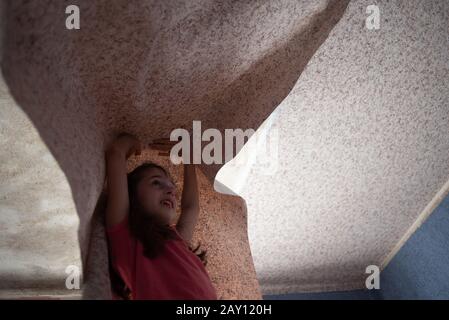 Donna appeso motivo carta da parati. Teen ragazza aiuta a incollare la carta da parati sul soffitto. Una ragazza di 9 anni aiuta i genitori a fare riparazioni in camera. Aiutare il bambino. Foto Stock