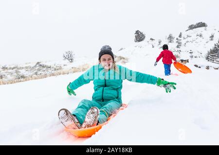 siblings slitta giù collina Foto Stock