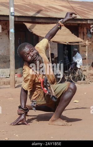 Kampala, Uganda - 3 febbraio 2015: Ritratto di un uomo nero di mezza età. Un uomo con disturbi mentali sta danzando in strada. Foto Stock