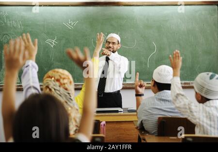 Insegnante con bambini in classe, ragazzi e ragazze a scuola insieme imparare, concorso Foto Stock