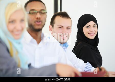 Gruppo d'affari arabo seduto in fila Foto Stock