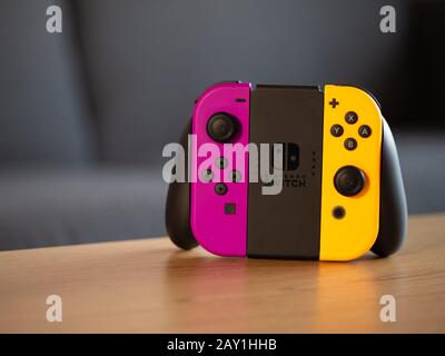 UK - Feb 2020: Nintendo Switch viola e arancio neon gioia con controller di giochi Foto Stock