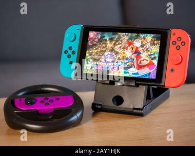 UK - Feb 2020: Console per giochi Nintendo Switch con home screen e wheel controller Mario Kart Foto Stock