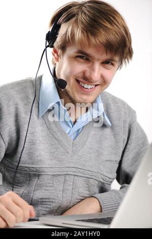 Ritratto di un giovane con una cuffia davanti a un computer portatile Foto Stock