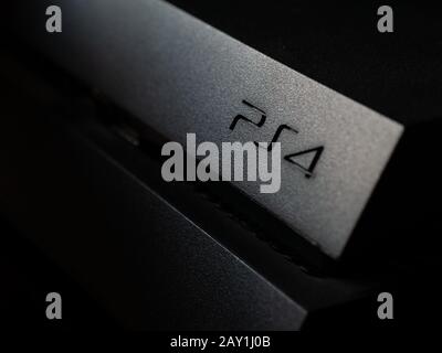 UK - Feb 2020: Sony Playstation 4 primo piano del logo su console buia Foto Stock