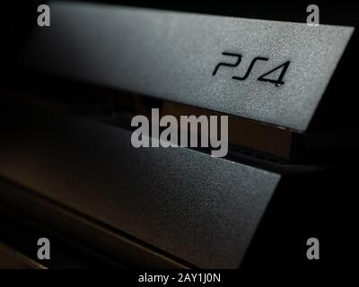 UK - Feb 2020: La console Sony Playstation 4 ha un'illuminazione spettacolare e scura sul logo Foto Stock