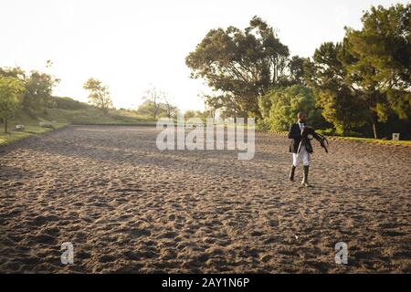 Uomo a piedi con sella di cavallo dressage Foto Stock