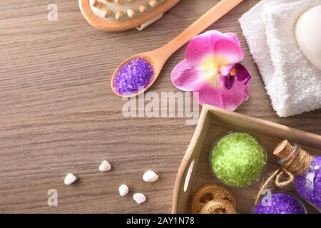 Sali, sapone e spazzola massaggiante su tavolo in legno. Prodotti per il benessere del corpo su vassoio in legno. Vista dall'alto. Composizione orizzontale. Foto Stock