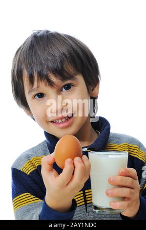 Carino ragazzino con bicchiere di latte e uova Foto Stock