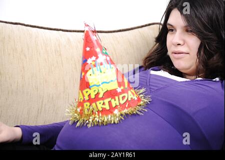 Giovane donna incinta seduta sul divano Foto Stock