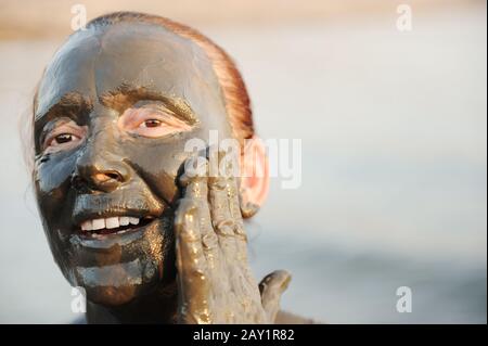 Donna anziana in costume da bagno di fango minerale naturale proveniente dal mare morto in Giordania Foto Stock