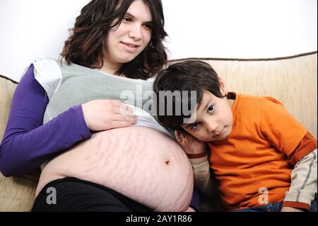 Un ragazzino e la madre incinta trascorrono del tempo insieme Foto Stock