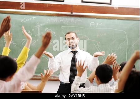Buon insegnante in classe davanti al tabellone Foto Stock