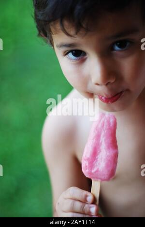 Un ragazzino sta succhiando un gelato Foto Stock