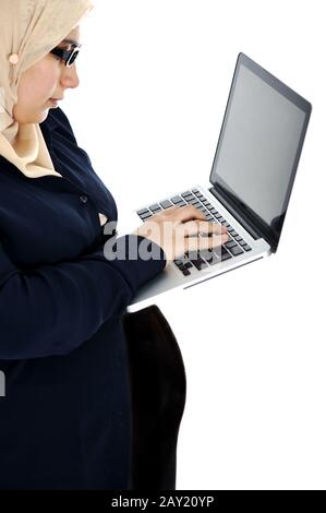 Donna araba musulmana incinta che usa un computer portatile Foto Stock