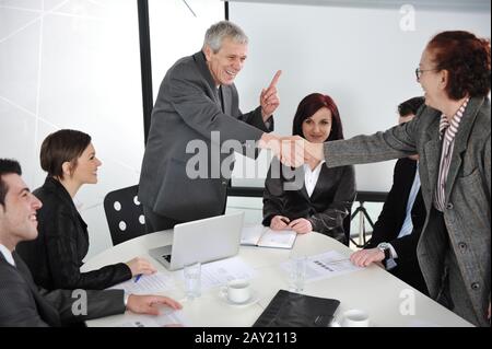 Due uomini d'affari senior che si scuotono le mani durante la riunione Foto Stock