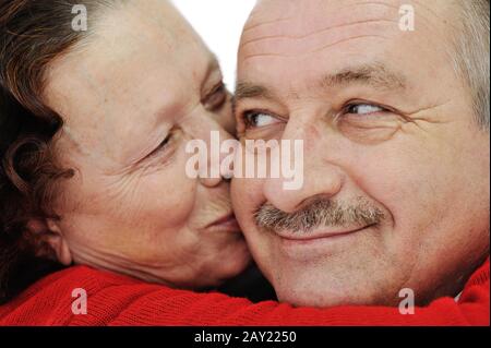 Immagine closeup di donna anziana baciando in una guancia suo marito Foto Stock