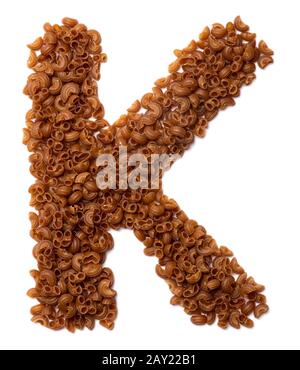 Lettera K dell'alfabeto inglese da pasta secca da farina di amaranto di grano saraceno su sfondo bianco isolato. Modello alimentare realizzato con provette di maccheroni. Foto Stock