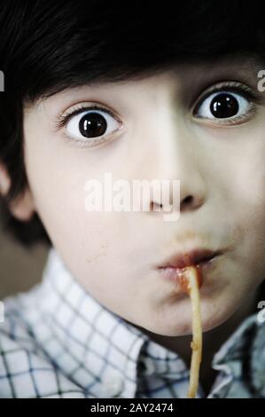 Ritratto di primo piano del ragazzino che mangia spaghetti Foto Stock