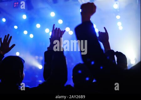 La folla dei concerti di fronte alle luci del palco Foto Stock