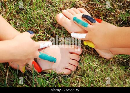 Colori su mano del bambino e mano sulla gamba Foto Stock