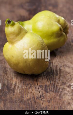 due quince su un asse di legno Foto Stock