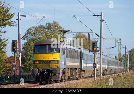 Una locomotiva elettrica di classe 90 numero 90009 che lavora un servizio National Express East Anglia a Marks Tey sulla Grande linea principale orientale. Foto Stock