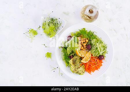 Insalata vegetariana piatto di Buddha con ceci, avocado, cetrioli, carote, semi di chia, insalata di lattuga e olive. Tendenza alimentare sana, superfood. T Foto Stock